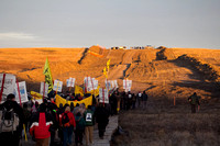 Native Americans and other DAPL Resistance members gather at sunrise for a 5 mile march to the DAPL construction site. Police and private security can be seen on the hill directly in the path of the D